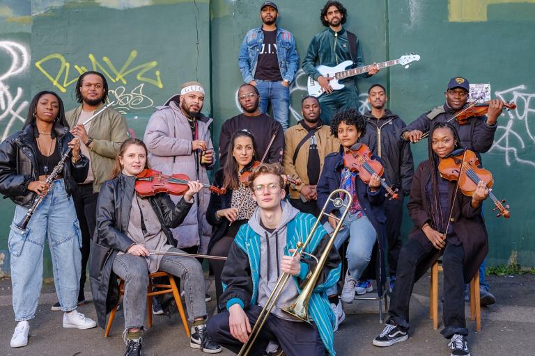 Brixton Chamber Orchestra pose for photo with their instruments in their hands.