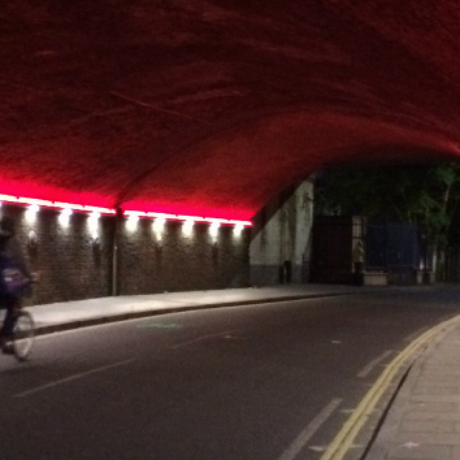 Person riding through lit up tunnel